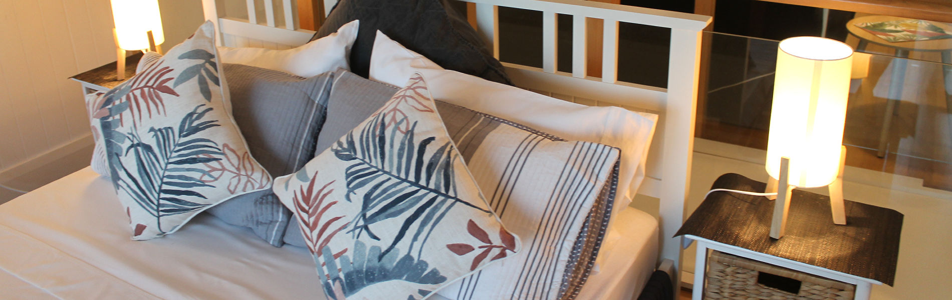 View of a comfortable queen-size bed with premium linens, pillows, and doona in a 5-star Oak Beach holiday accommodation