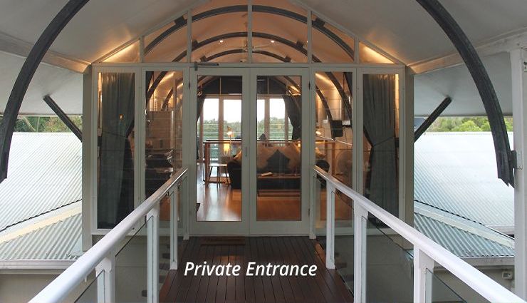 Private entrance to guest accommodation leading from the timber deck walkway through glass doors